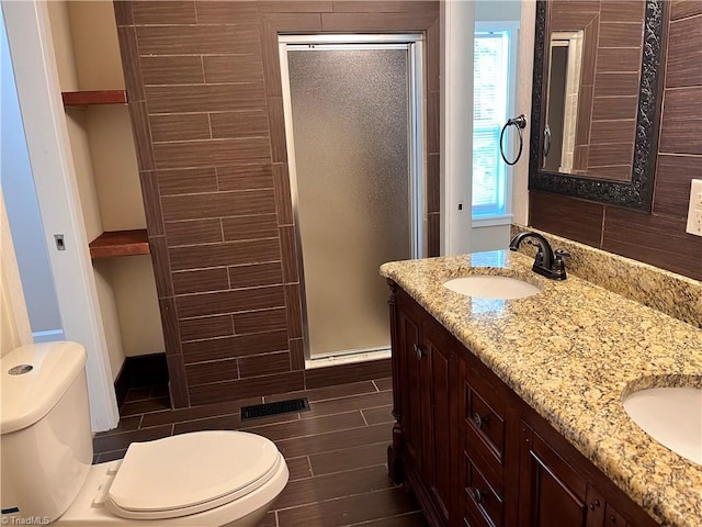 bathroom featuring hardwood / wood-style floors, walk in shower, vanity, and toilet