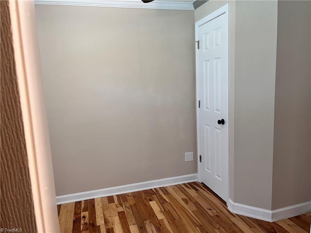 empty room featuring ornamental molding and hardwood / wood-style floors