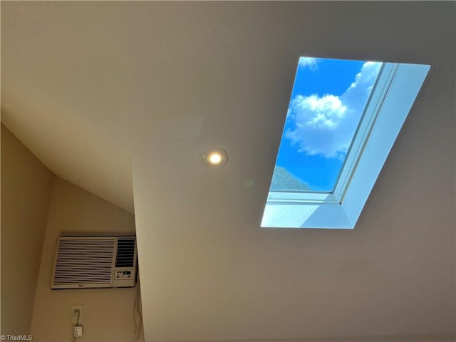 interior details featuring a skylight and a wall mounted air conditioner