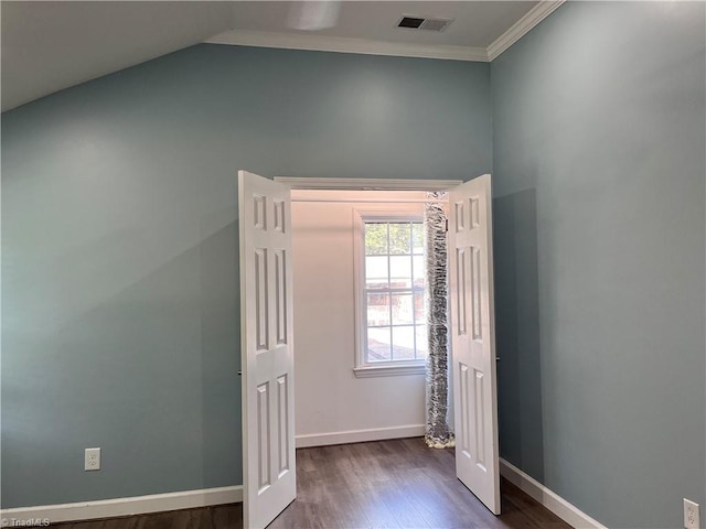 unfurnished bedroom featuring lofted ceiling, dark hardwood / wood-style floors, and crown molding