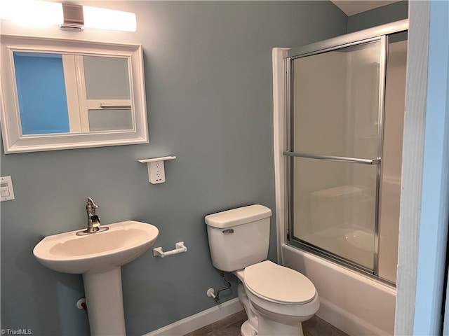 bathroom with shower / bath combination with glass door, toilet, and tile patterned floors