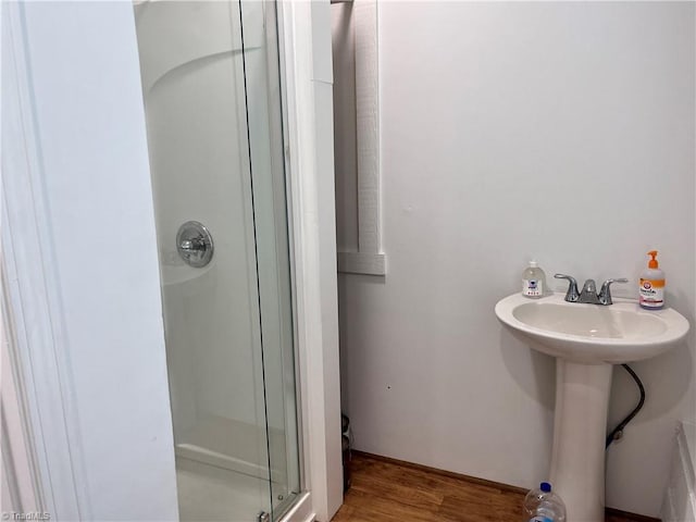 bathroom featuring wood-type flooring and a shower with door