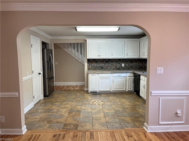 kitchen featuring white cabinetry, backsplash, dark hardwood / wood-style flooring, stainless steel refrigerator with ice dispenser, and ornamental molding