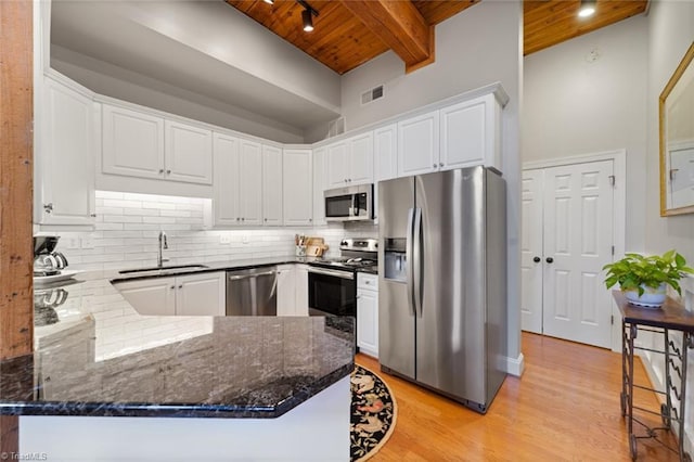 kitchen with visible vents, a sink, decorative backsplash, stainless steel appliances, and wood ceiling