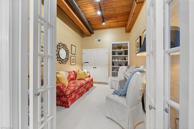 living area with visible vents, beam ceiling, wooden ceiling, and french doors