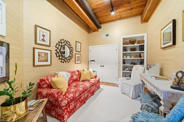 living area with wooden ceiling, beamed ceiling, wood finished floors, and visible vents