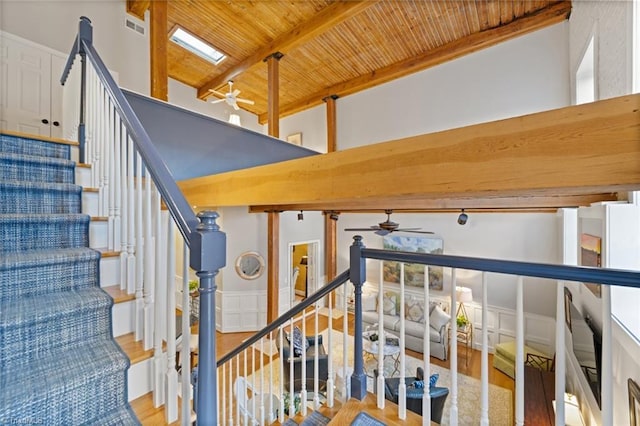 staircase featuring beamed ceiling, high vaulted ceiling, wood finished floors, wooden ceiling, and ceiling fan