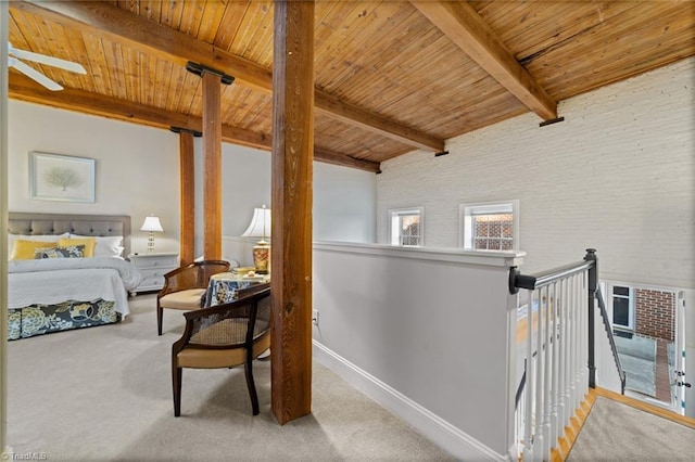 bedroom featuring baseboards, carpet floors, beam ceiling, and wooden ceiling