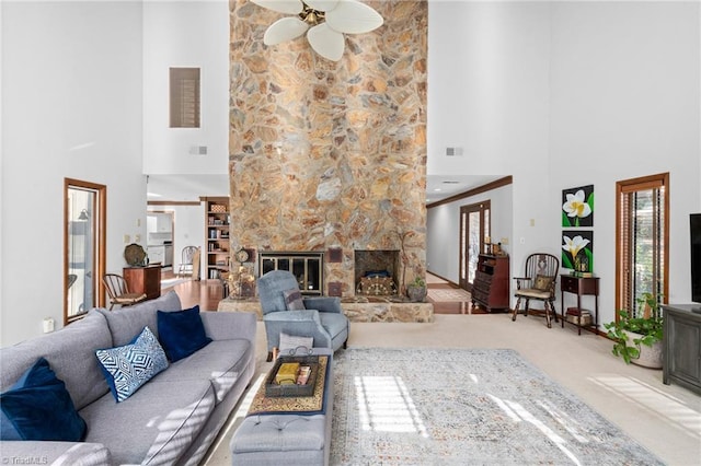 living room featuring visible vents, carpet flooring, a fireplace, and ceiling fan