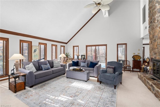 living room featuring high vaulted ceiling, a ceiling fan, carpet, a fireplace, and crown molding