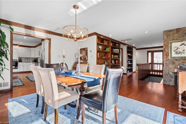 dining space featuring an inviting chandelier, recessed lighting, wood finished floors, and ornamental molding