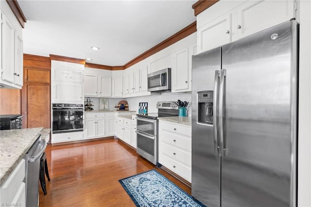 kitchen with tasteful backsplash, dark wood-style floors, appliances with stainless steel finishes, white cabinets, and light stone countertops