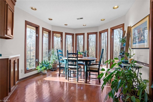 dining area featuring a wealth of natural light, visible vents, baseboards, and wood finished floors