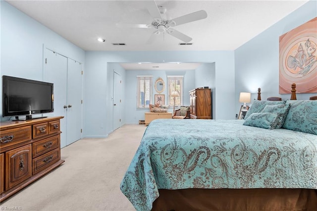 bedroom featuring visible vents, light carpet, baseboards, and ceiling fan