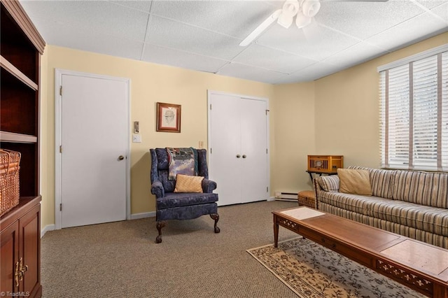 carpeted living room with baseboard heating and a ceiling fan