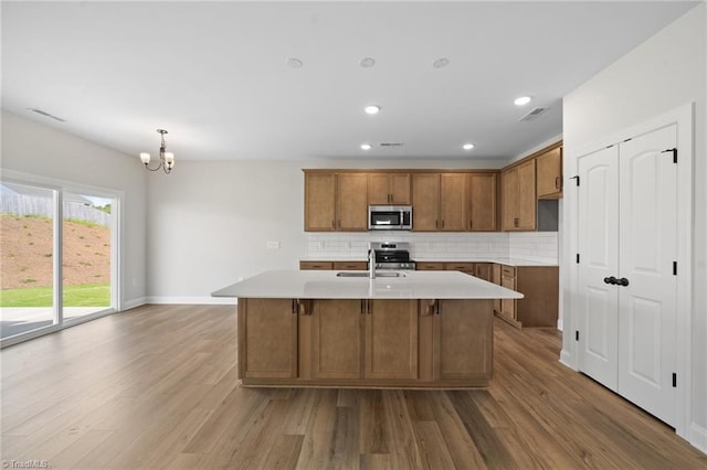 5751 Siler St, Trinity, NC 27370 - kitchen with backsplash, stainless steel appliances, brown cabinets, and wood finished floors