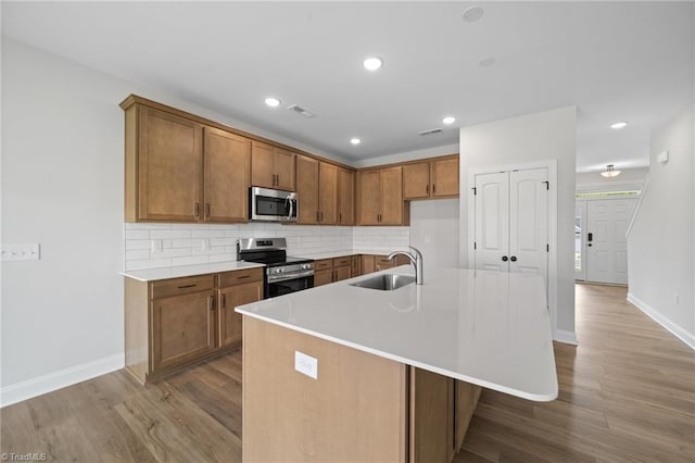 5751 Siler St, Trinity, NC 27370 - kitchen with wood finished floors, baseboards, brown cabinets, a sink, and stainless steel appliances