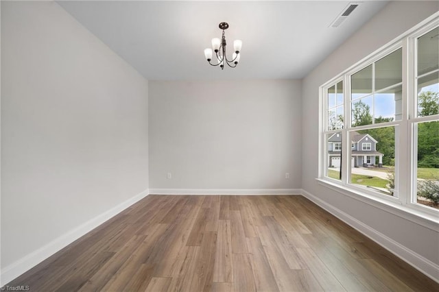 5751 Siler St, Trinity, NC 27370 - empty room featuring visible vents, baseboards, wood finished floors, and a notable chandelier