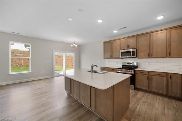 5751 Siler St, Trinity, NC 27370 - kitchen with visible vents, light wood-type flooring, a sink, a notable chandelier, and stainless steel appliances