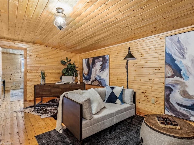 sitting room featuring wooden walls, hardwood / wood-style floors, wood ceiling, and vaulted ceiling