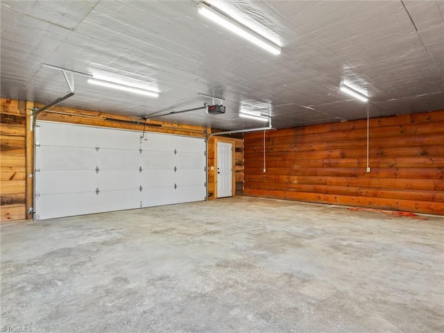 garage with wooden walls and a garage door opener