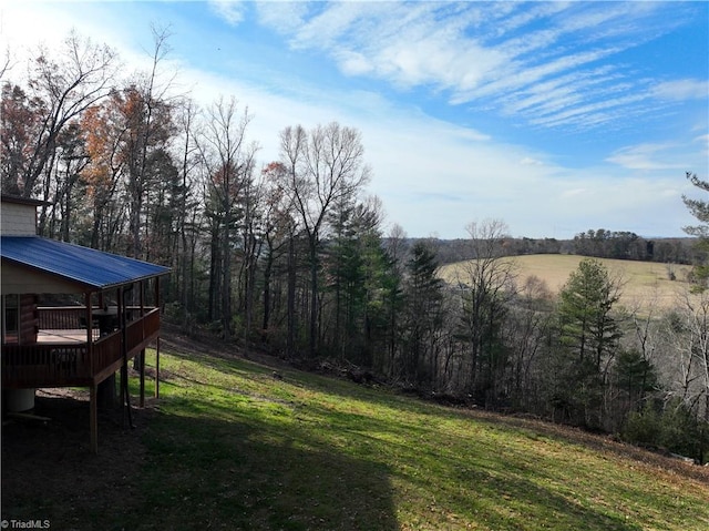 view of yard featuring a wooden deck and a rural view