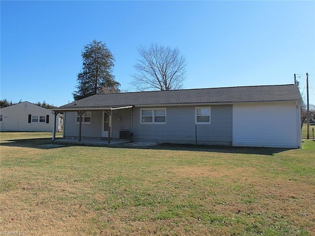 rear view of property with a lawn and central AC