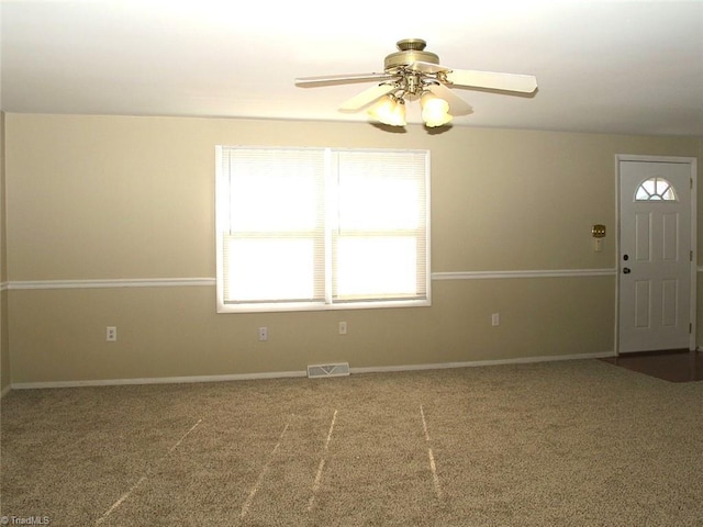 spare room featuring ceiling fan and carpet