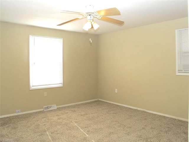 carpeted spare room with ceiling fan