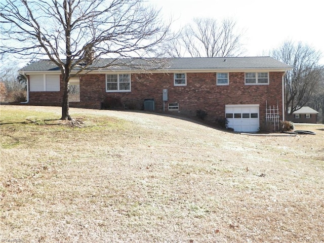 exterior space with cooling unit, a yard, and a garage