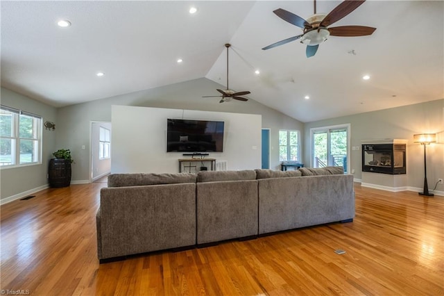 living room featuring lofted ceiling, ceiling fan, plenty of natural light, and wood finished floors