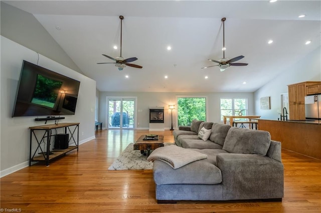 living room featuring a ceiling fan, recessed lighting, and light wood-type flooring