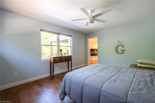 bedroom featuring wood finished floors, baseboards, and a ceiling fan