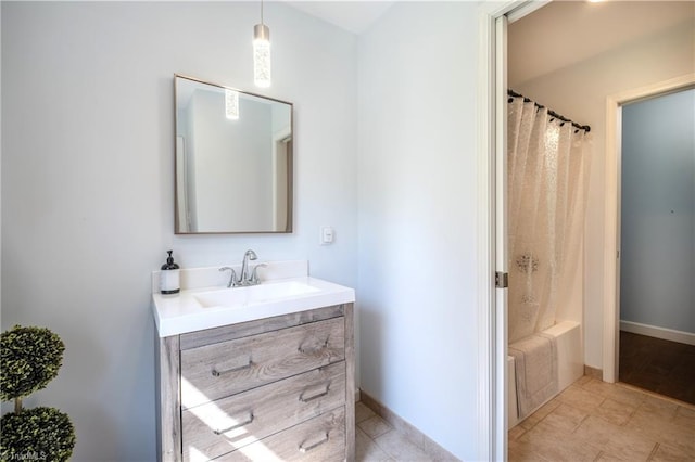 bathroom with vanity, baseboards, and tile patterned flooring