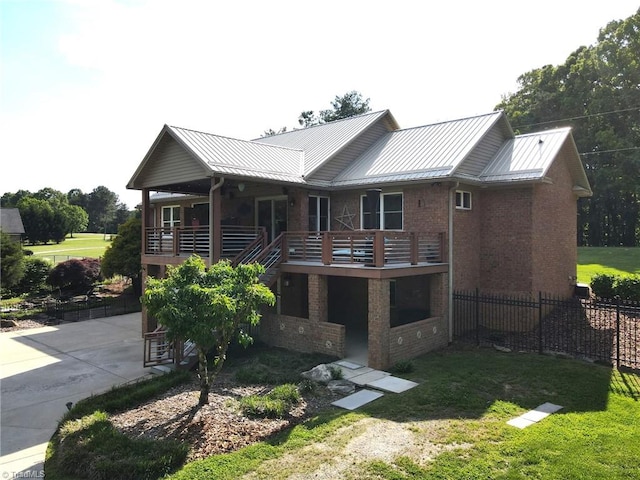 back of property featuring a yard, metal roof, and a standing seam roof