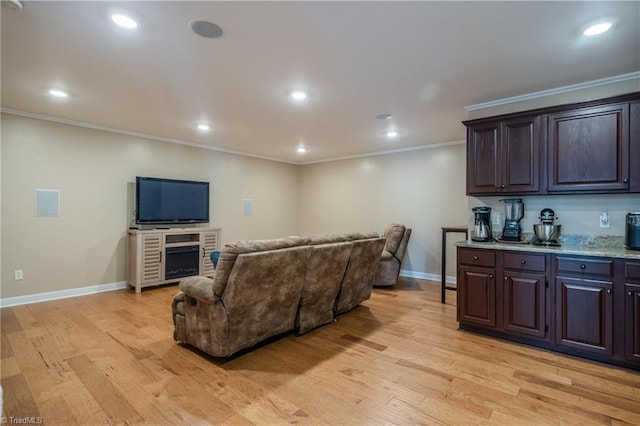 living room featuring crown molding, baseboards, light wood-type flooring, and recessed lighting