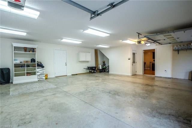 garage with baseboards and a garage door opener