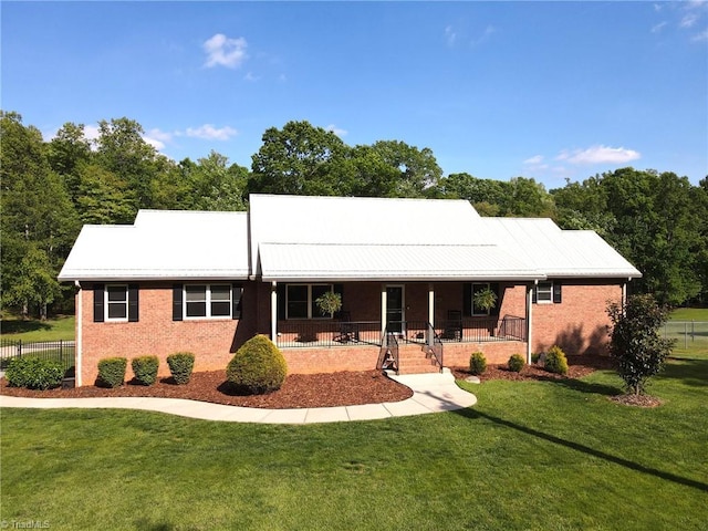 view of front of house with covered porch, a front lawn, and brick siding