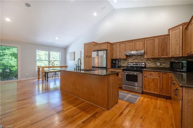kitchen with under cabinet range hood, brown cabinets, a sink, and appliances with stainless steel finishes