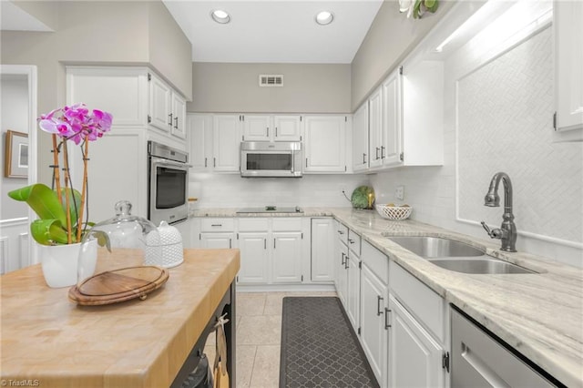 149 Warwicke Pl, Bermuda Run, NC 27006 - kitchen featuring appliances with stainless steel finishes, a sink, backsplash, white cabinetry, and recessed lighting