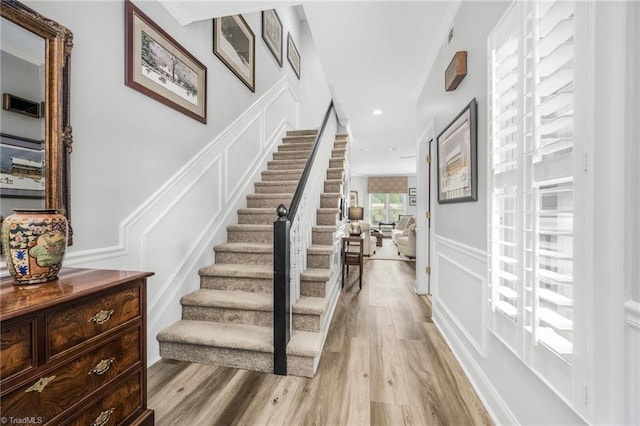 149 Warwicke Pl, Bermuda Run, NC 27006 - stairs with a decorative wall, wood finished floors, recessed lighting, and a wainscoted wall