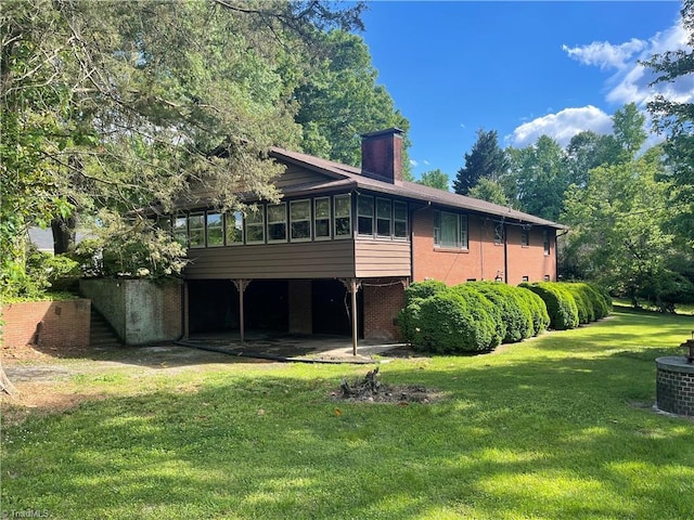1706 Windsor Dr, High Point, NC 27262 - rear view of property with a sunroom, brick siding, a yard, a chimney, and central air condition unit