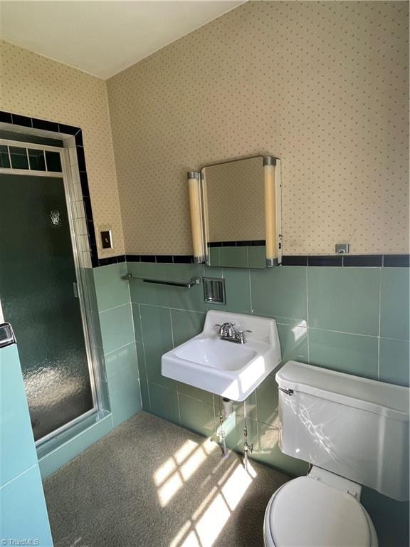 1706 Windsor Dr, High Point, NC 27262 - bathroom featuring wallpapered walls, toilet, tile walls, a wainscoted wall, and a sink