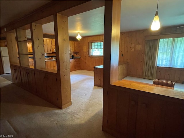 1706 Windsor Dr, High Point, NC 27262 - kitchen featuring freestanding refrigerator, carpet flooring, wood walls, and pendant lighting