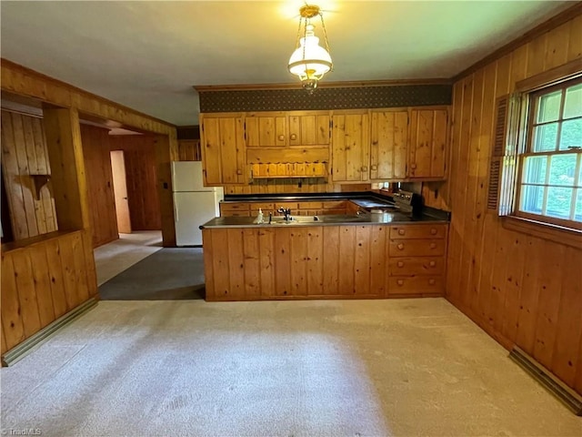 1706 Windsor Dr, High Point, NC 27262 - kitchen with freestanding refrigerator, crown molding, wooden walls, brown cabinetry, and a peninsula
