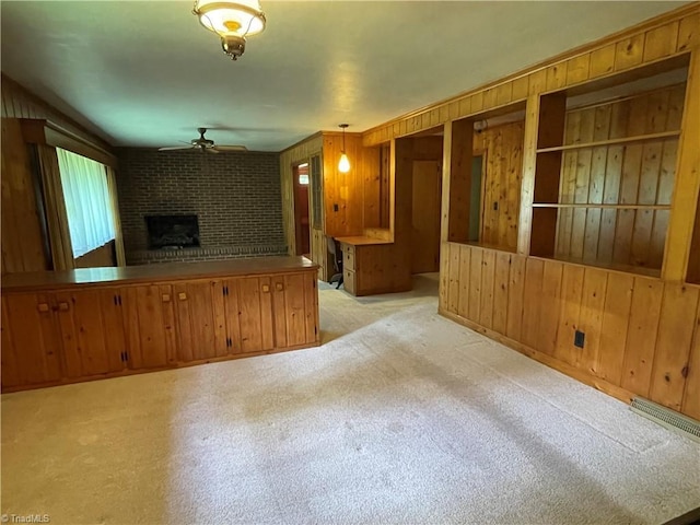 1706 Windsor Dr, High Point, NC 27262 - unfurnished living room featuring a ceiling fan, wood walls, and a brick fireplace