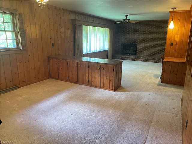 1706 Windsor Dr, High Point, NC 27262 - unfurnished living room with ceiling fan, carpet floors, a brick fireplace, and wood walls