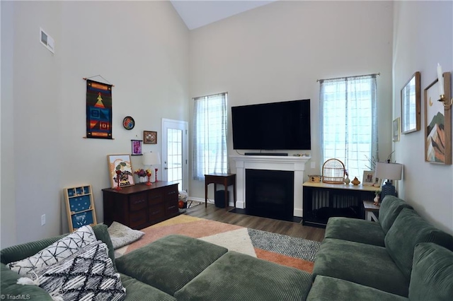 547 Historic Dr, Hillsborough, NC 27278 - living area featuring wood finished floors, a fireplace with flush hearth, baseboards, a high ceiling, and visible vents