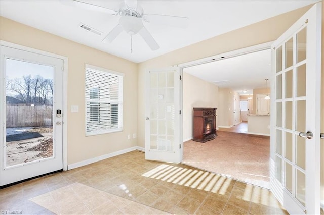 doorway to outside with light carpet, ceiling fan, and french doors