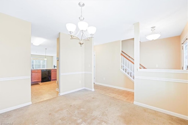 empty room featuring light colored carpet and a chandelier